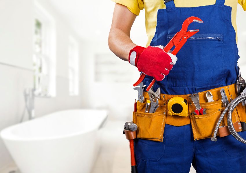 contract in overalls and red gloves holding a wrench